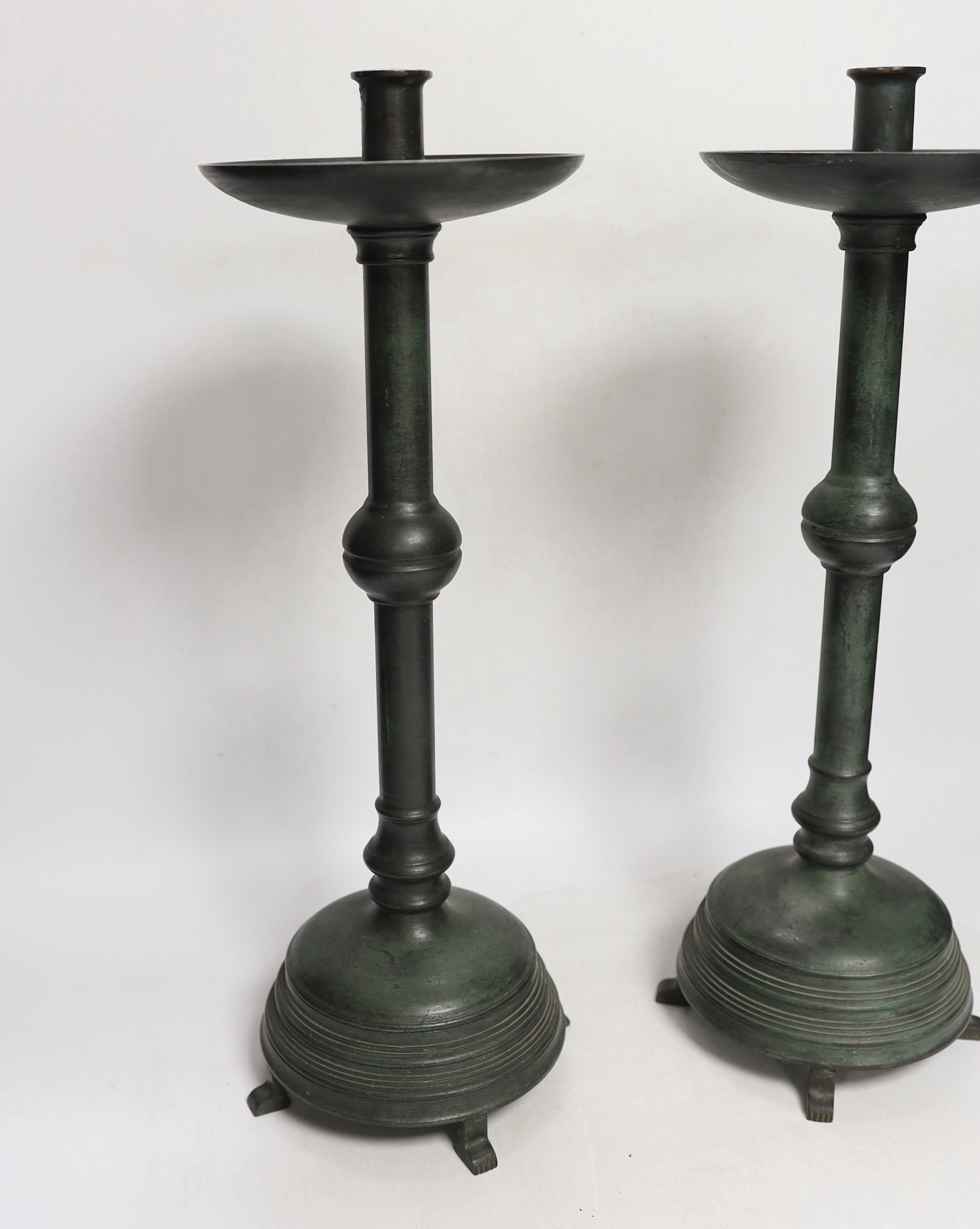 A pair of bronze candlesticks, 45.5cm, and a pair of stags, all with green patina